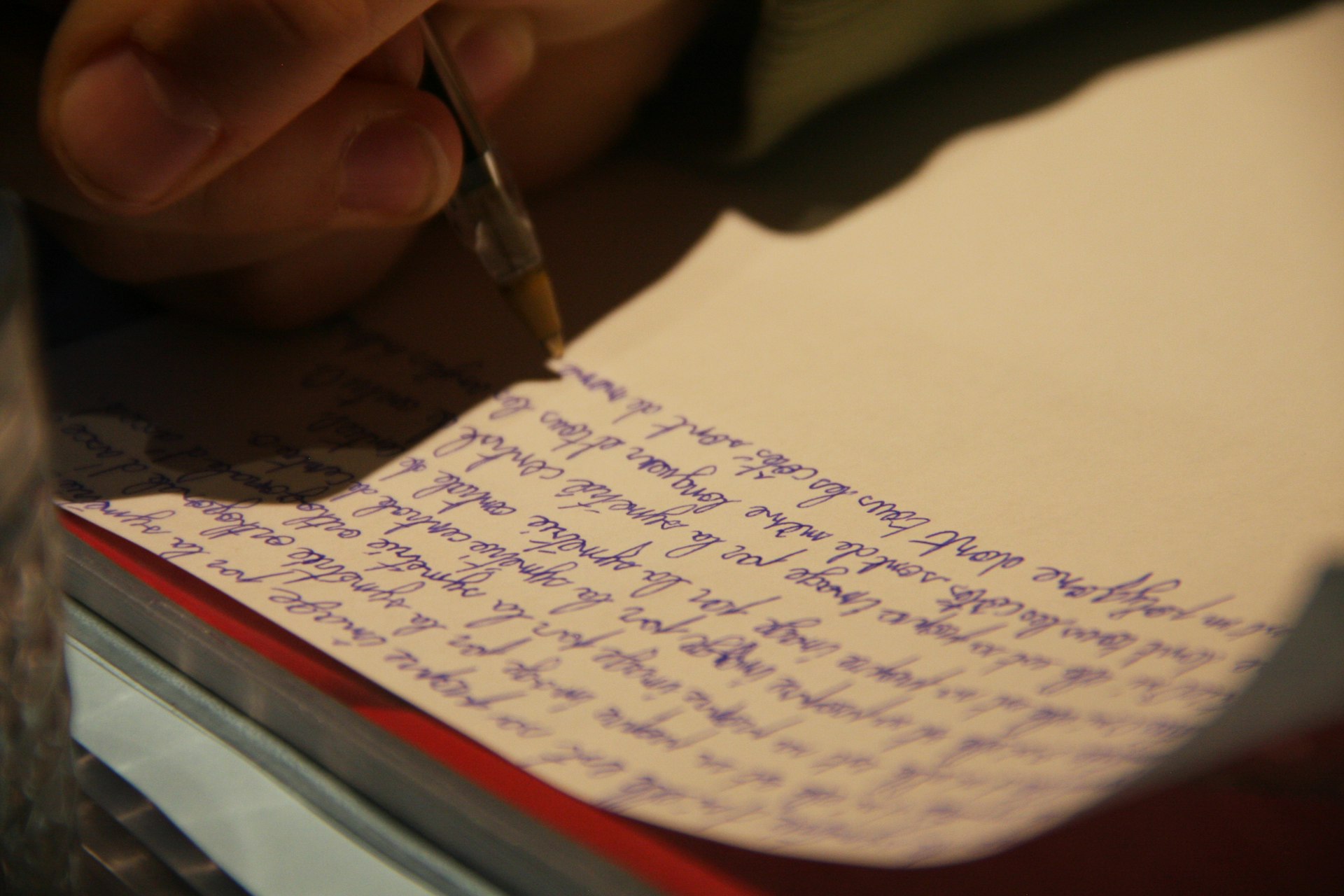 a person writing on a piece of paper with a pen